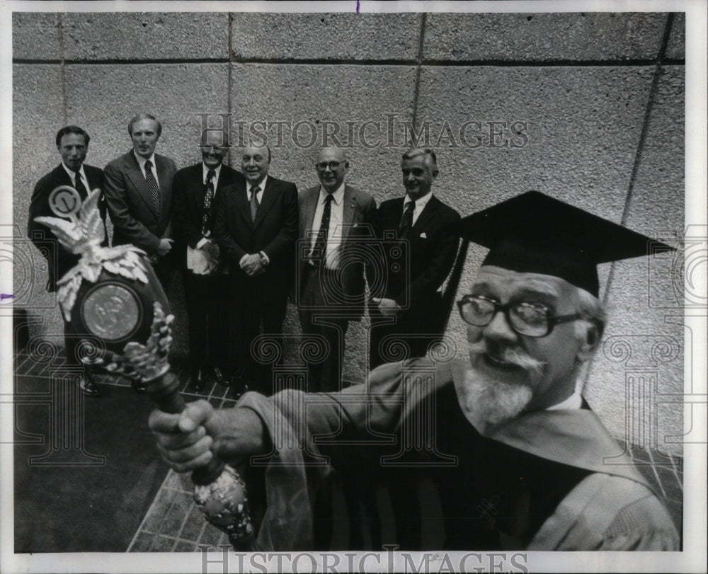 1976, Dr. John Graettinger holding mace. - RRU92927 - Historic Images