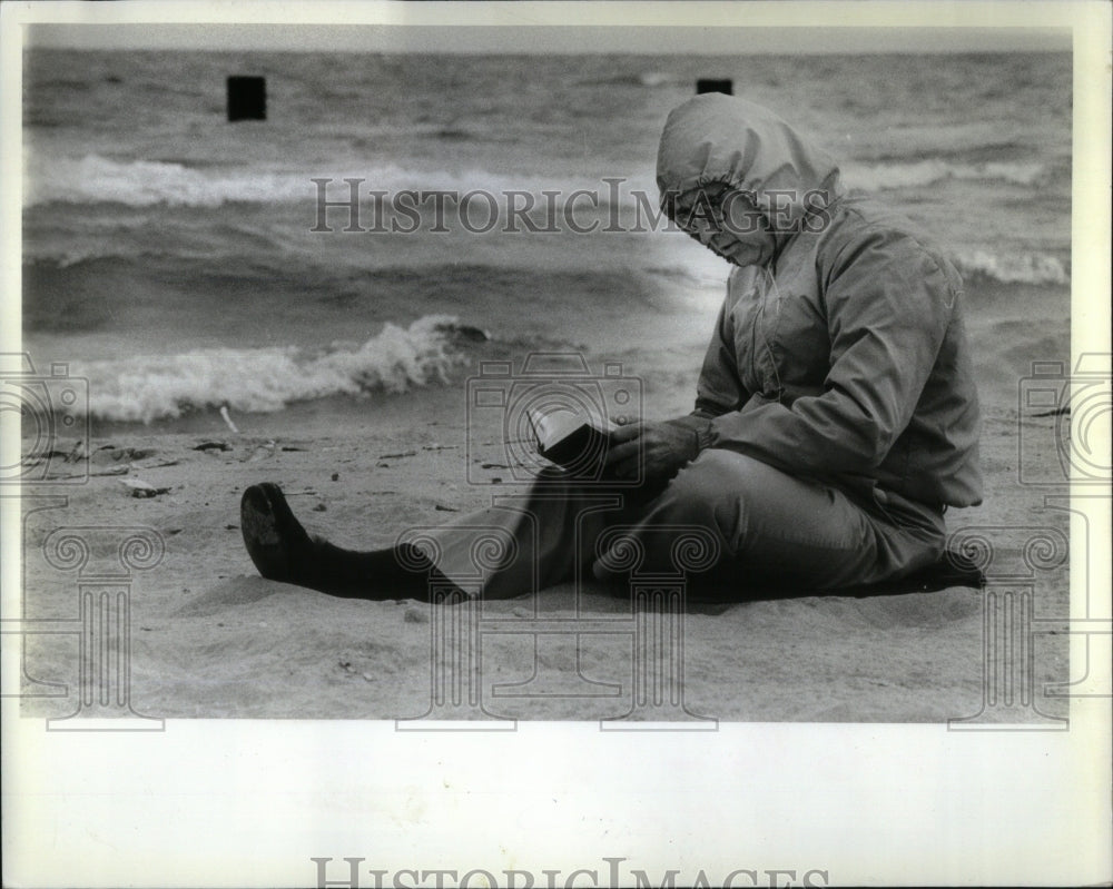 1982 Press Photo Hull reads on a deserted beach. - RRU92967 - Historic Images