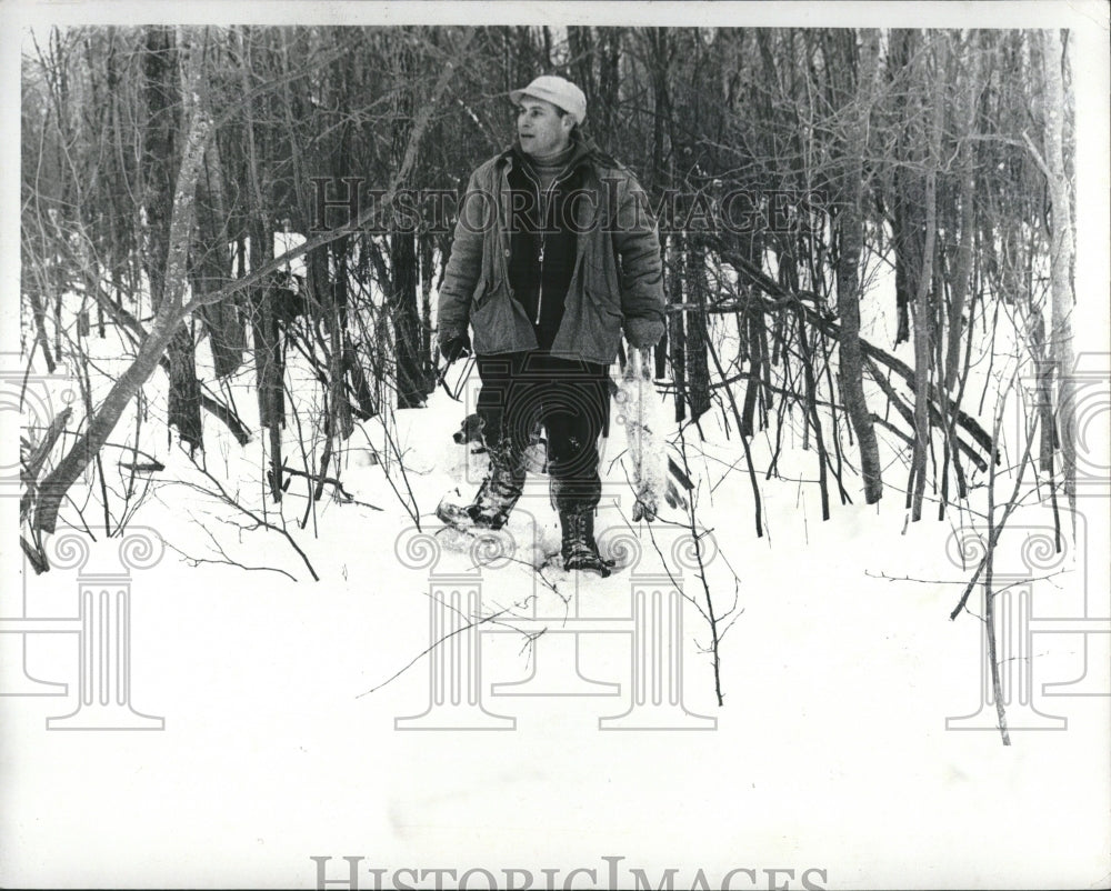 1977, Man wears snowshoes walking protect - RRV01671 - Historic Images