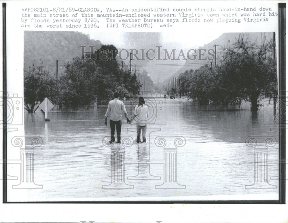 1969 Couple walking in flooded street,W.V. - Historic Images