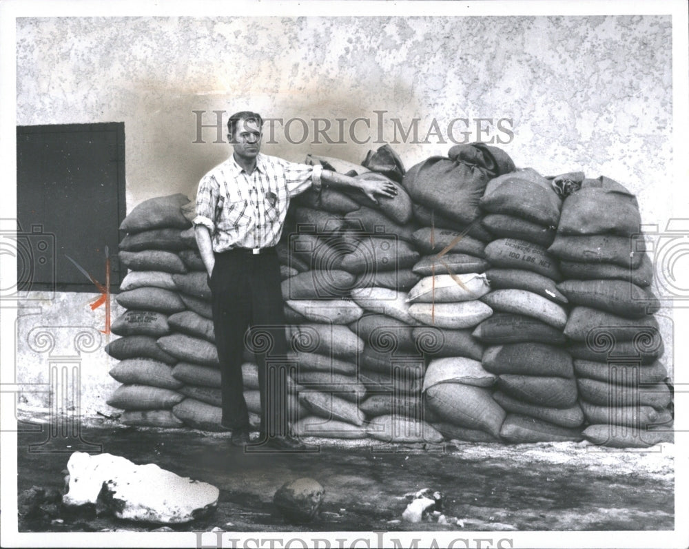 1965 Ed Wolfe with sandbags before a flood - Historic Images