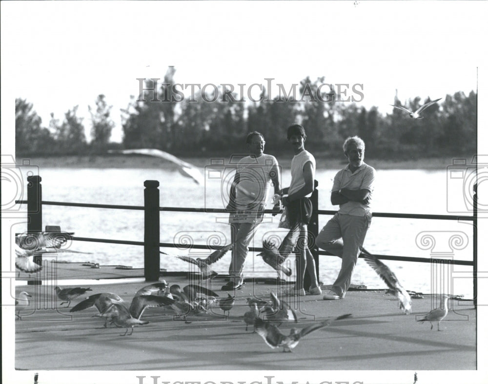 1990 Men Feed Birds Grand Haven Boardwalk - Historic Images