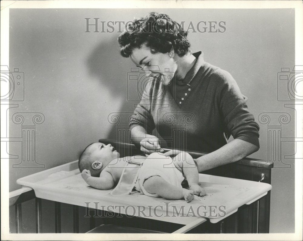 1960, Mother dressing kid face smile - RRV90221 - Historic Images