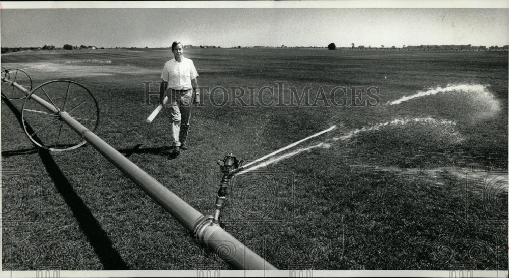 1991 Press Photo Farmer inspecting irrigation device. - RRW04927 - Historic Images