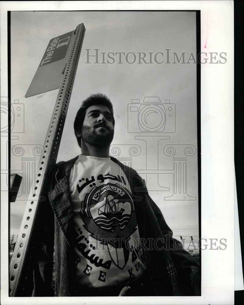 1991 Press Photo Man Waiting For Bus Arabic Shirt - RRW08975 - Historic Images