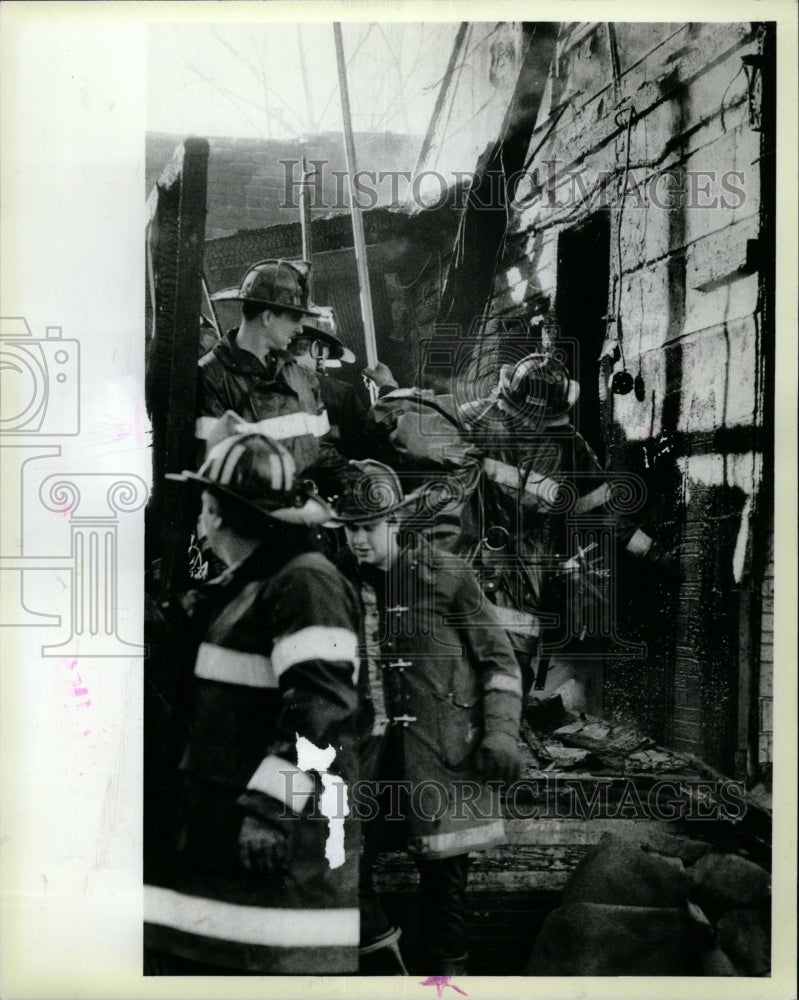 1984 Press Photo Firefighter Child Frame House James - RRW23669 - Historic Images