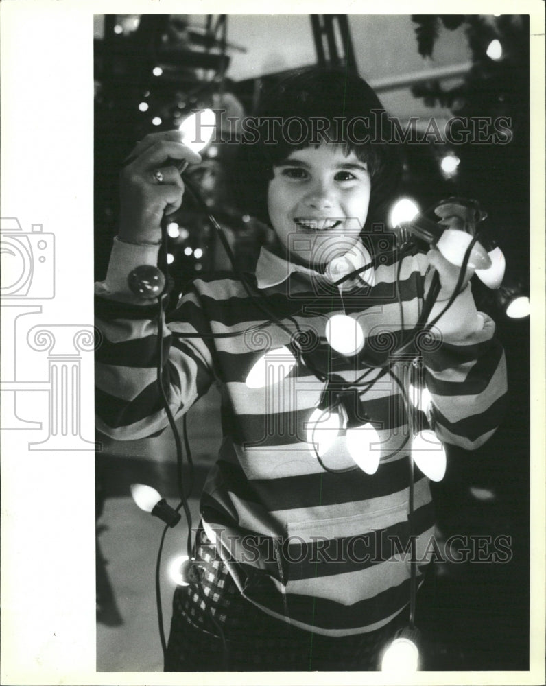 1984 Press Photo Girl Holding Christmas Tree Lights - RRW29327 - Historic Images