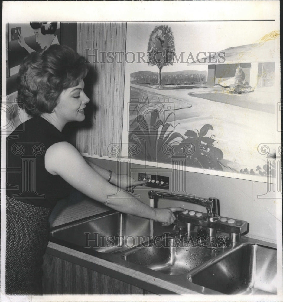 Press Photo Woman demonstrating automatic sink - RRW39959 - Historic Images