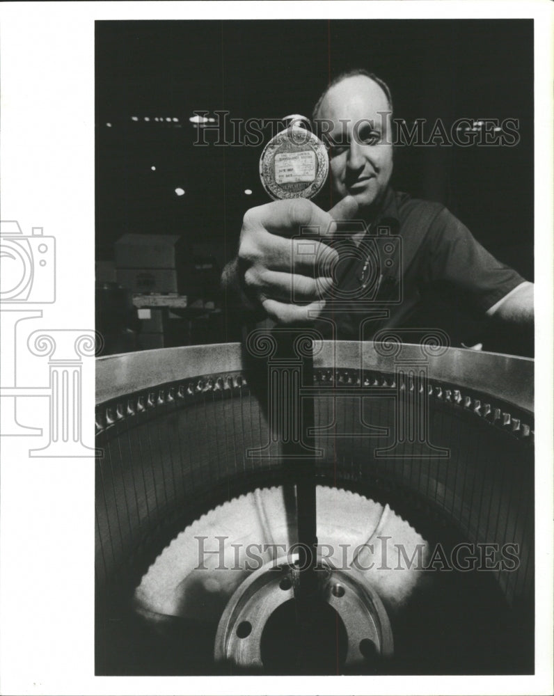 Press Photo Man Holding something like a gear. - RRW48279 - Historic Images