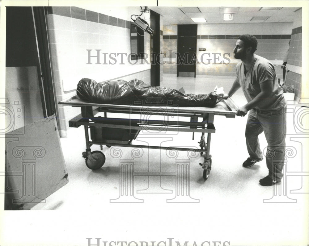 1987 Press Photo Man Wheeling Body Xray Forensic Inst - RRW54379 - Historic Images