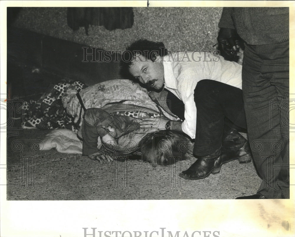 1984 Press Photo Man com forts one three people injured - RRW54715 - Historic Images