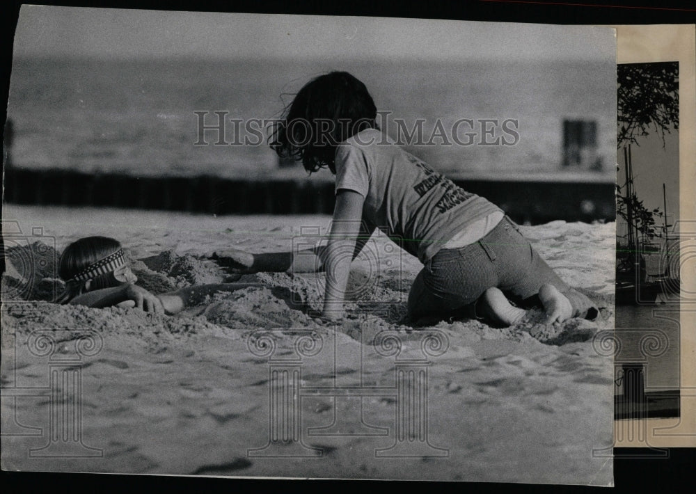 1976 Press Photo Chicago Man Buried In Sand Playing - RRW63129 - Historic Images