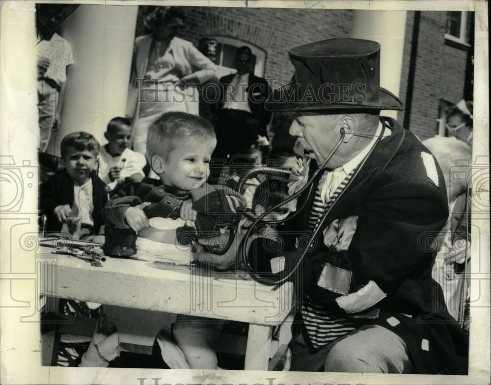 1963 Press Photo Man Dressed As Clown Entertains Child - RRW63723 - Historic Images