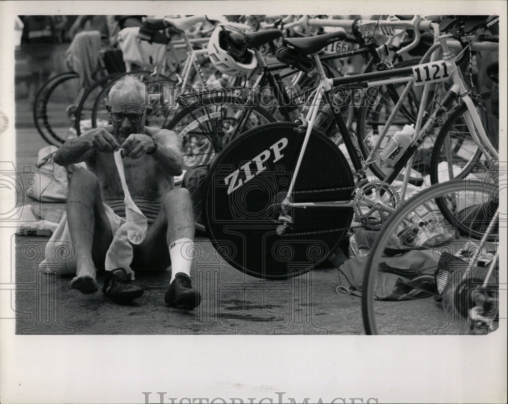 1990 Press Photo Triathlon athlete struggles bicycle - RRW93331 - Historic Images