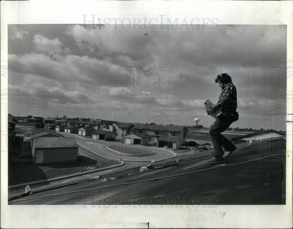 1975 Workman Completing roofing of new hous - Historic Images