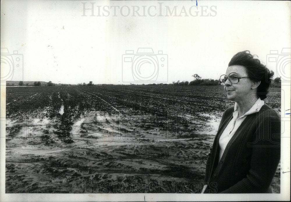 1980 Norma Rourke standing on a damage fiel - Historic Images