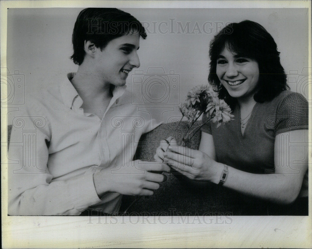 1984 girl receiving flowers from boyfriend - Historic Images