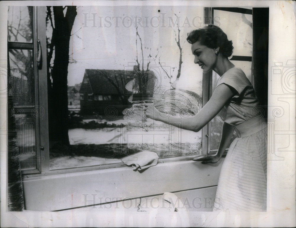 1961 housewife doing chores. - Historic Images