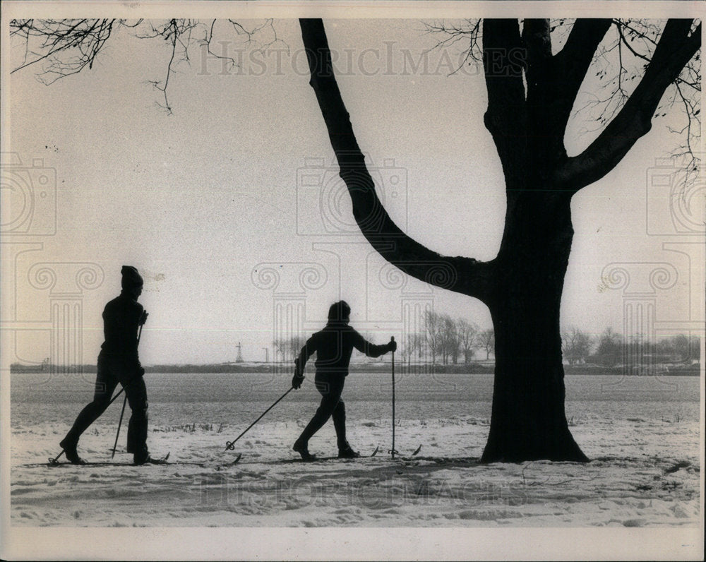 1981 Winter skiers snow traverse lake still - Historic Images