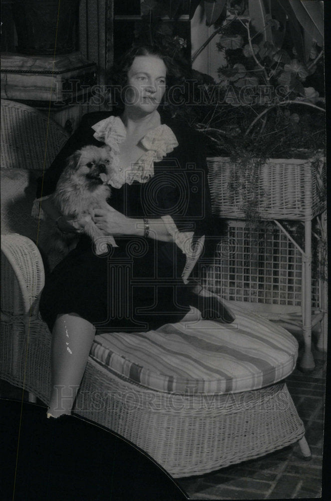 Press Photo Woman Rests On Chair While Holding Dog - Historic Images