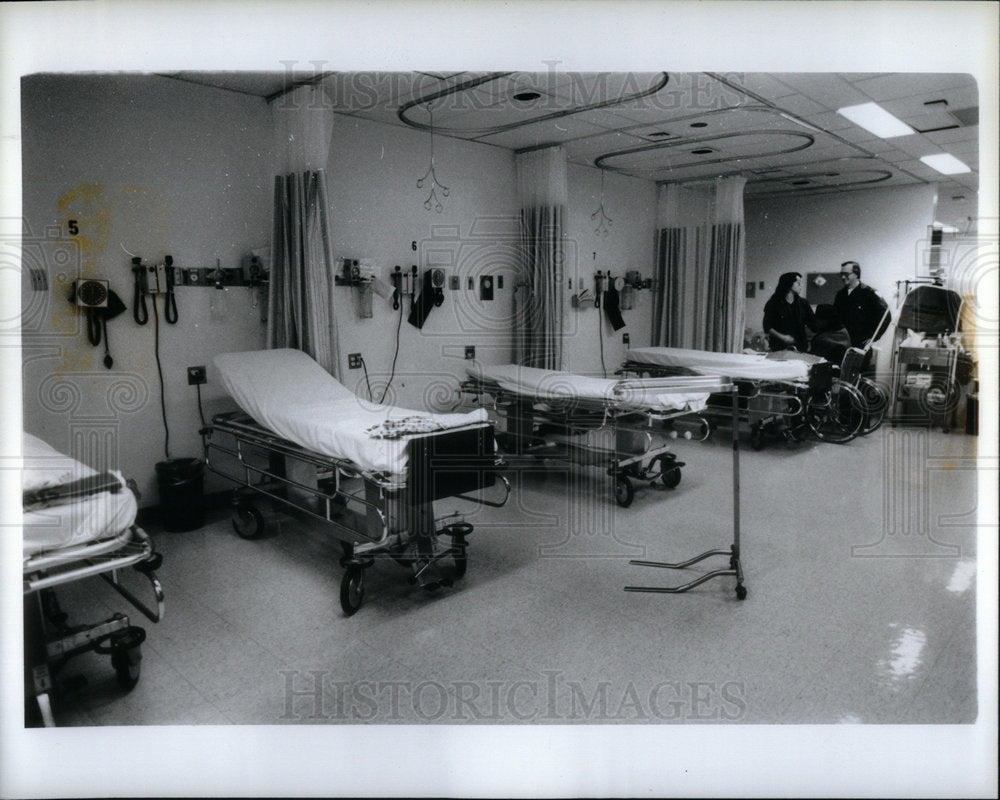 1983 Press Photo Doctor foreground empty room with bed - Historic Images