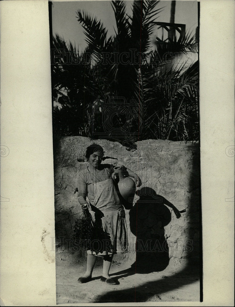 Press Photo Algerian Woman Holds Basket Jug - Historic Images