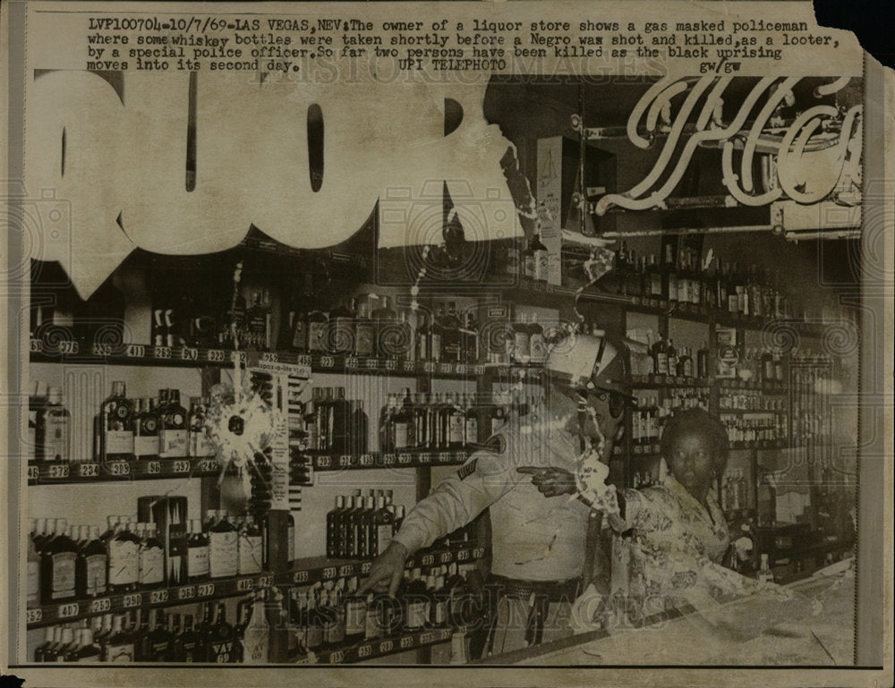 1969 Press Photo Liquor Store Owner Directs Policeman - Historic Images