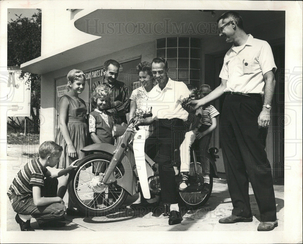 Press Photo A Man On A Bicycle With Two Children - Historic Images