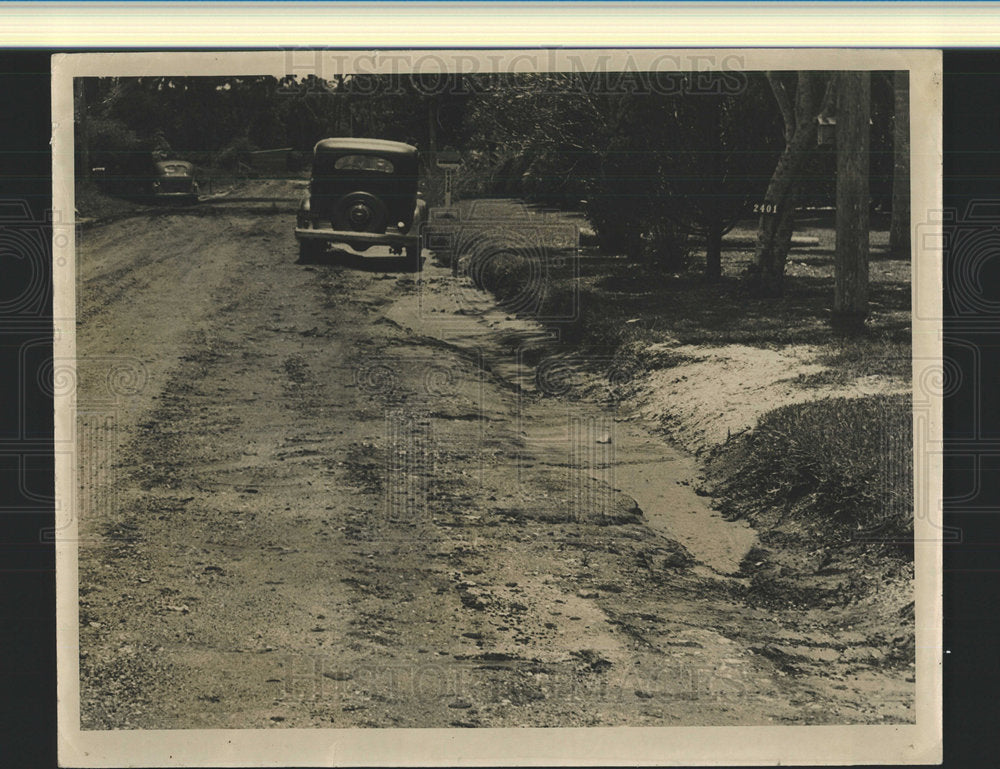 Press Photo Car Driving On Eroded Street Residential - Historic Images