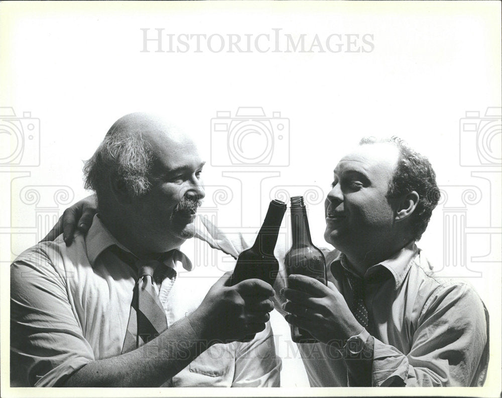 1986 Press Photo Two Men Bumping Beer Bottles - Historic Images