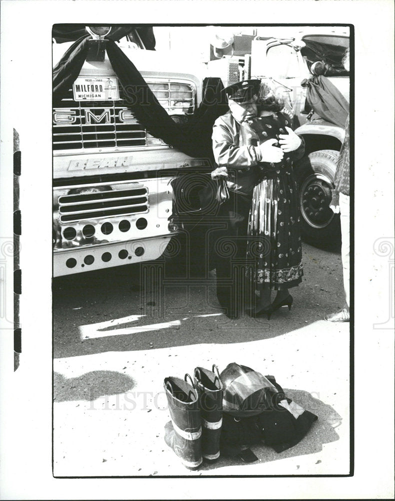 1987 Press Photo Mil Ford fire man Hugs Fire Fighter - Historic Images