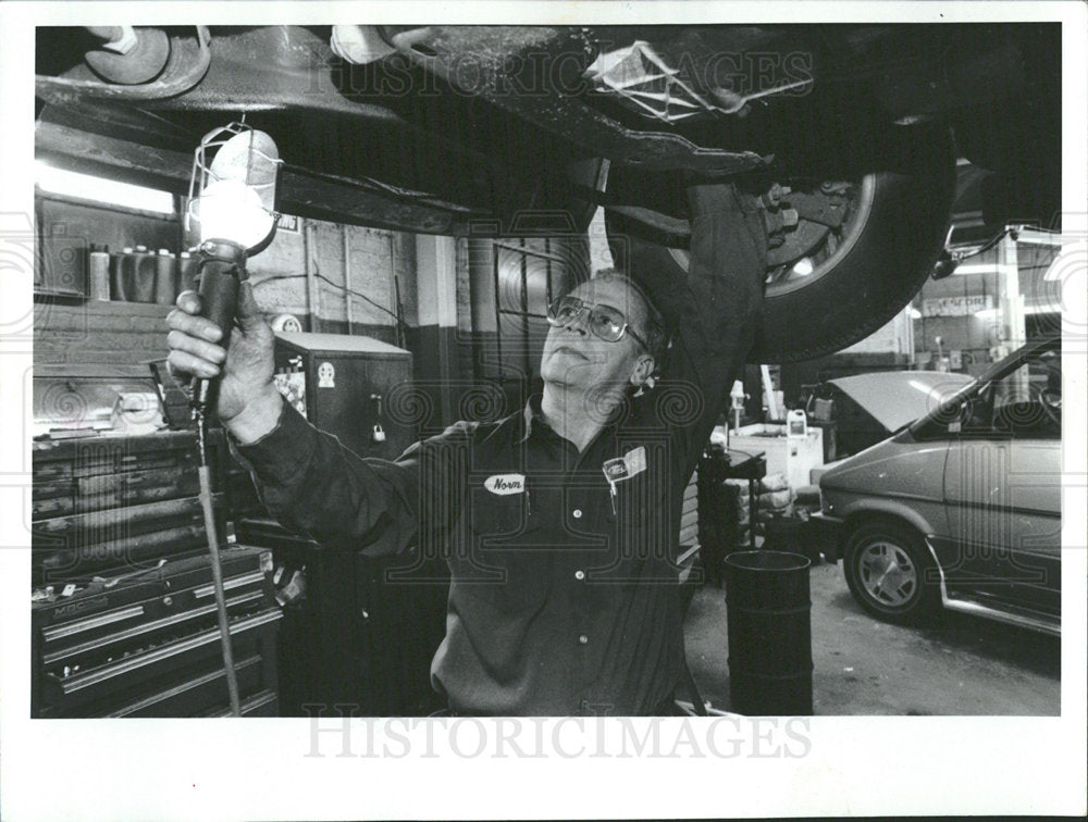 1994 Press Photo Schea Checks Ford Undercarriage - Historic Images