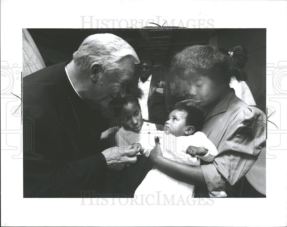 1991 Press Photo Archbishop greets 4-month old George. - Historic Images
