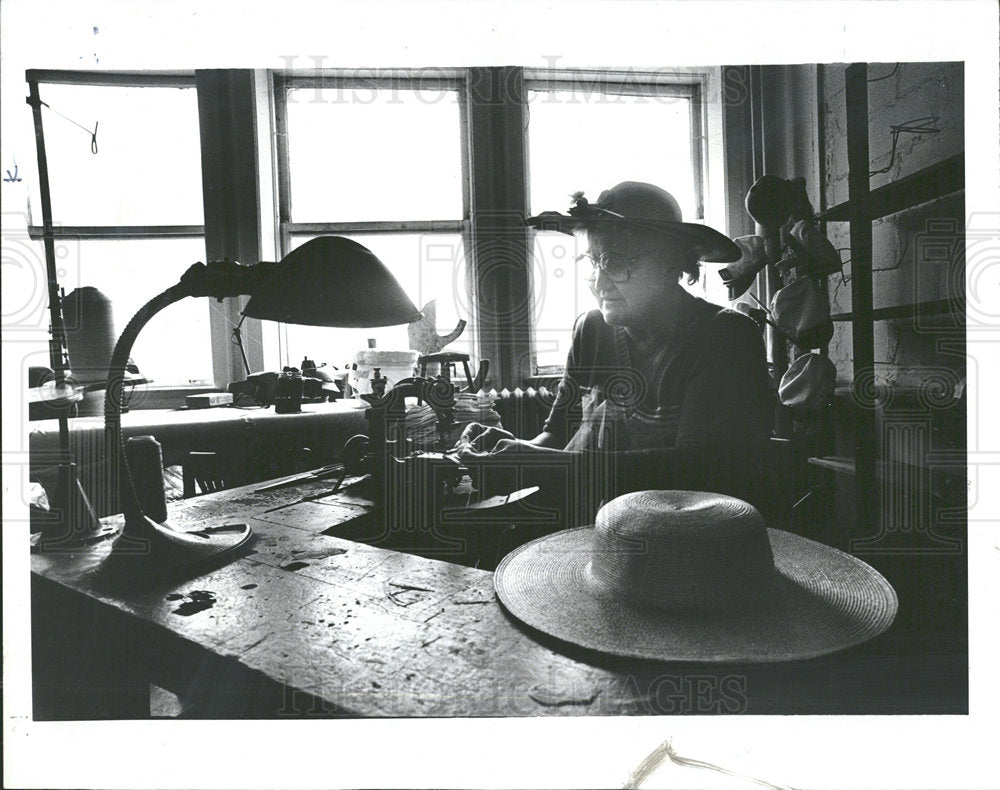 1985 Press Photo Store Owner Shell With Hats Desk - Historic Images