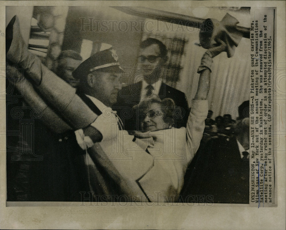 1965 Press Photo Woman Carried Out Of Annual Meeting - Historic Images