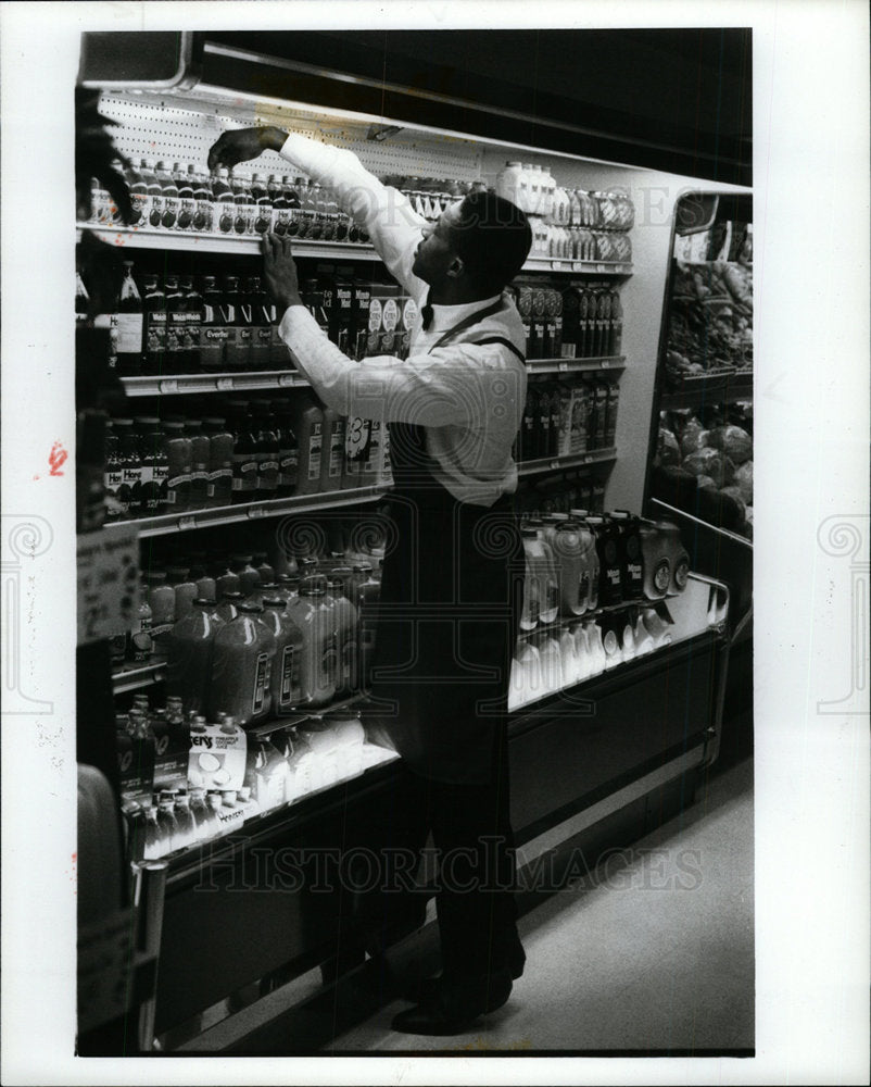 1988 Press Photo Dairy Clerk Stocking Dairy goods. - Historic Images