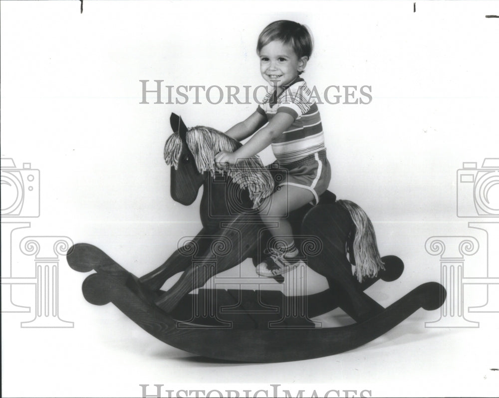 1992 Press Photo Child playing game rocking horse doll - Historic Images