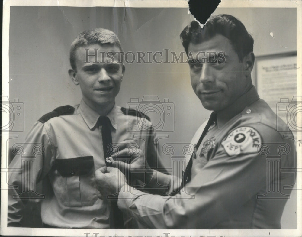 1965 Officer James Alfano pins tie clasp to - Historic Images