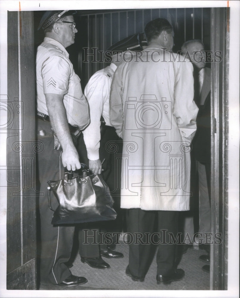 1961 Sgt. Arthur Minton holds black purse of slain Gertrude Lewandow - Historic Images