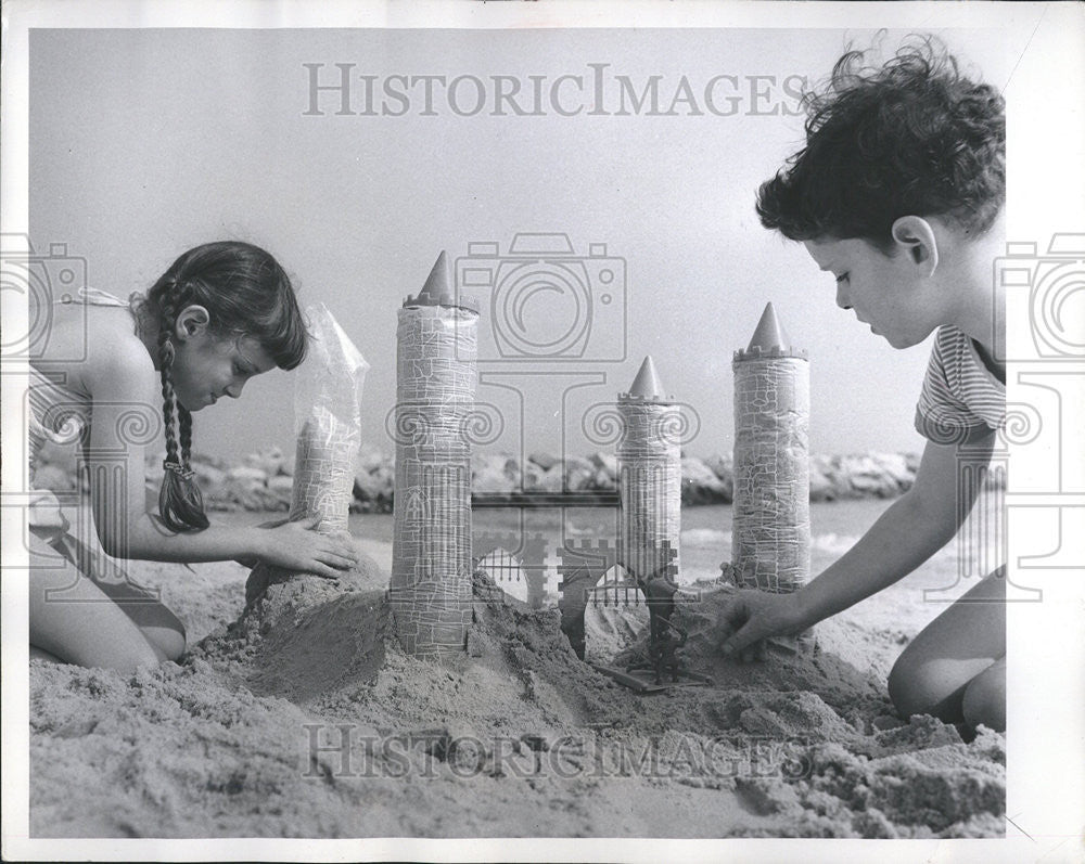 1957 Press Photo Plastic bags Brick Gate Drawbridge Turrets Beach Toys - Historic Images