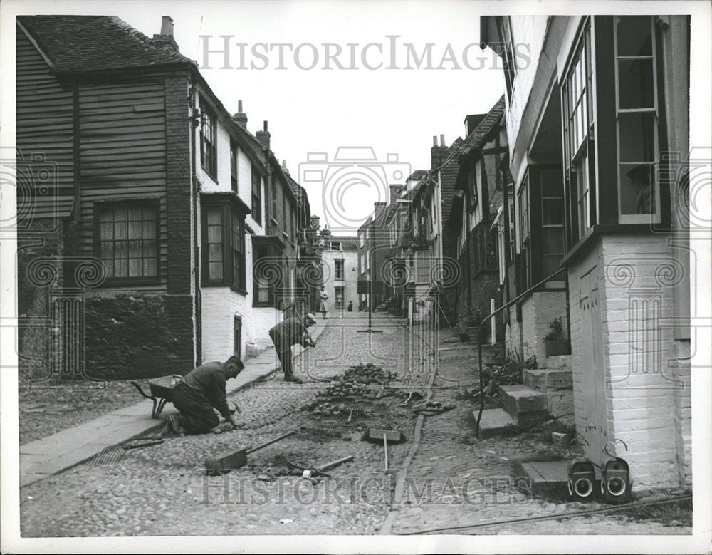 1956 Press Photo Workmen in Rye, England repair cobblestones in Mermaid St. - Historic Images