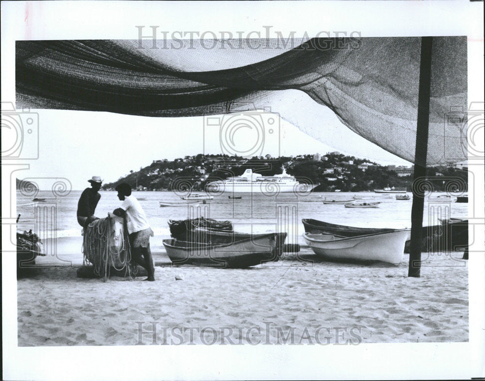 1982 Press Photo Fishermen wait for others on the shore of Acapulco Bay - Historic Images