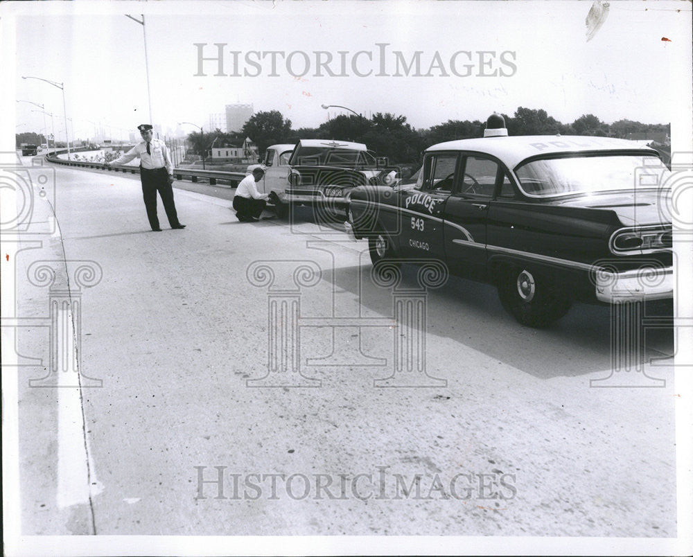 1958 Press Photo Repairing a flat tire on the busy Chicago sky way. - Historic Images