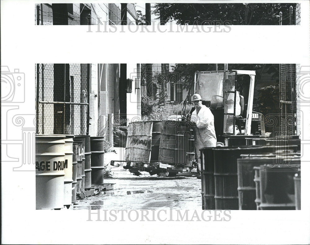 1984 Press Photo Sheller Globe Corp Worker Wheeling Toxic Waste Barrel - Historic Images