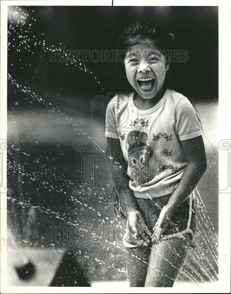 1987 Press Photo A Small Girl Playing in Spray in a Hot Day. - Historic Images