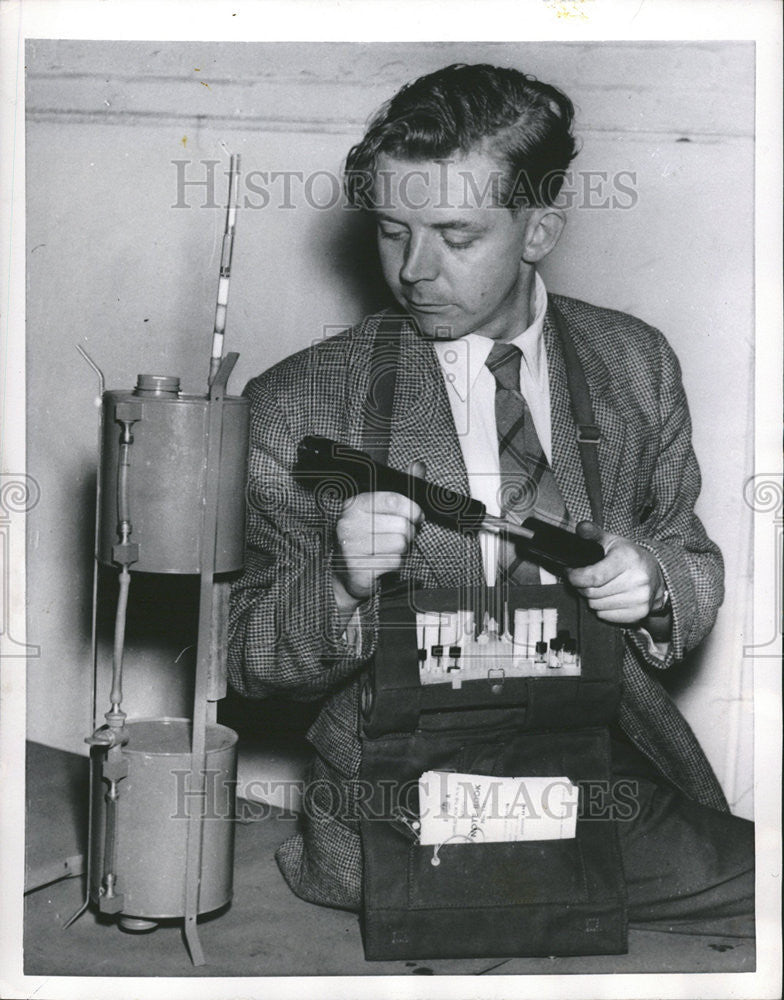 1954 Press Photo Dr. G.H. Booth inspects apparatus for measuring the amount polt - Historic Images