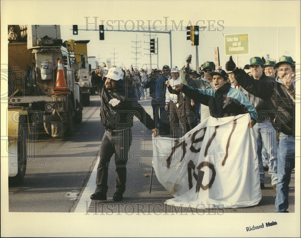 1992 Press Photo Striking Caterpillar worker Machine Steve Blyskal American Flag - Historic Images