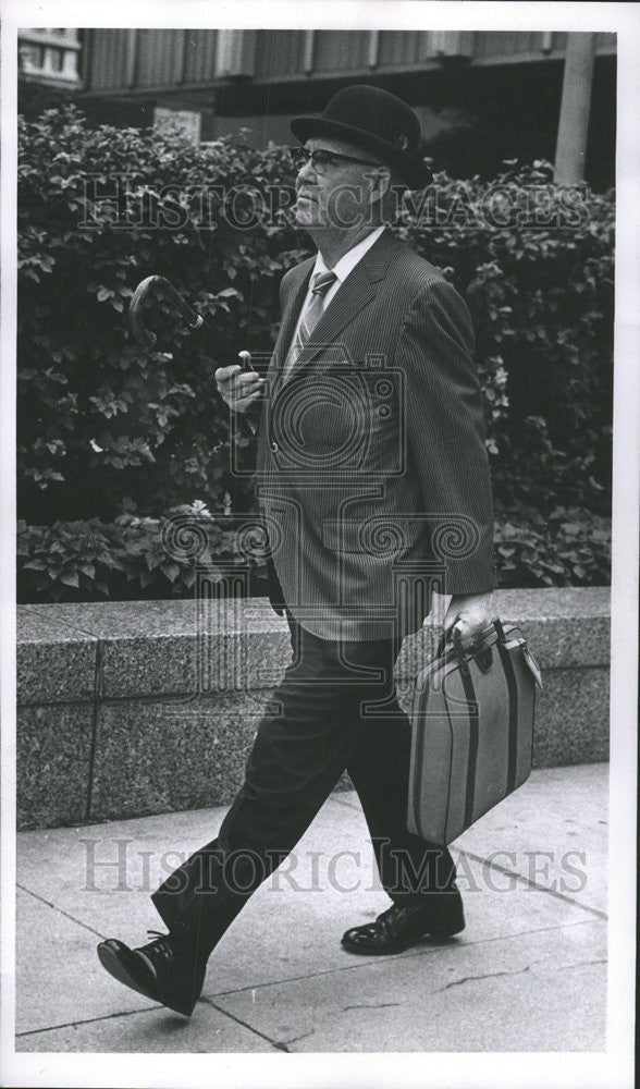 1970 Press Photo Wada Franklin traveling leather bag hand Black suit. - Historic Images