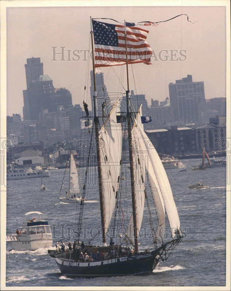 1986 Press Photo small ship flying American flag sails past Statue Liberty - Historic Images