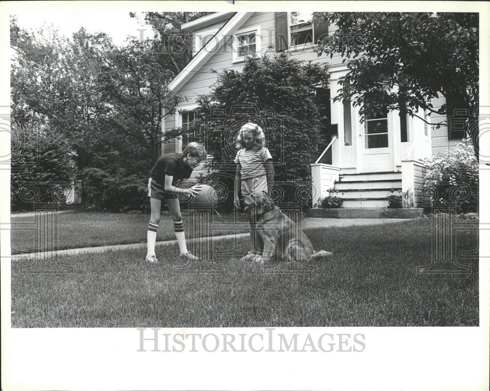 1984 Press Photo Danny &amp; Molly Harmon play with their dog. - Historic Images